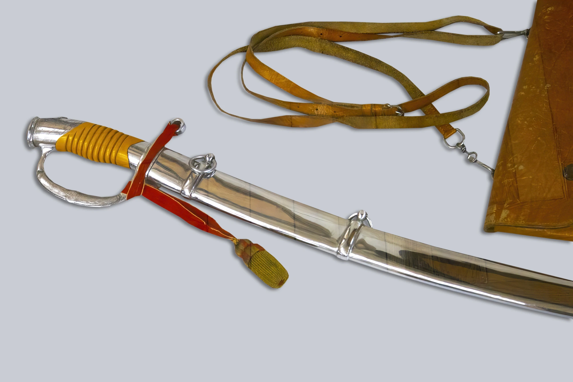 A sabre with a polished blade and scabbard, featuring an ornately decorated handle, displayed against a neutral background.