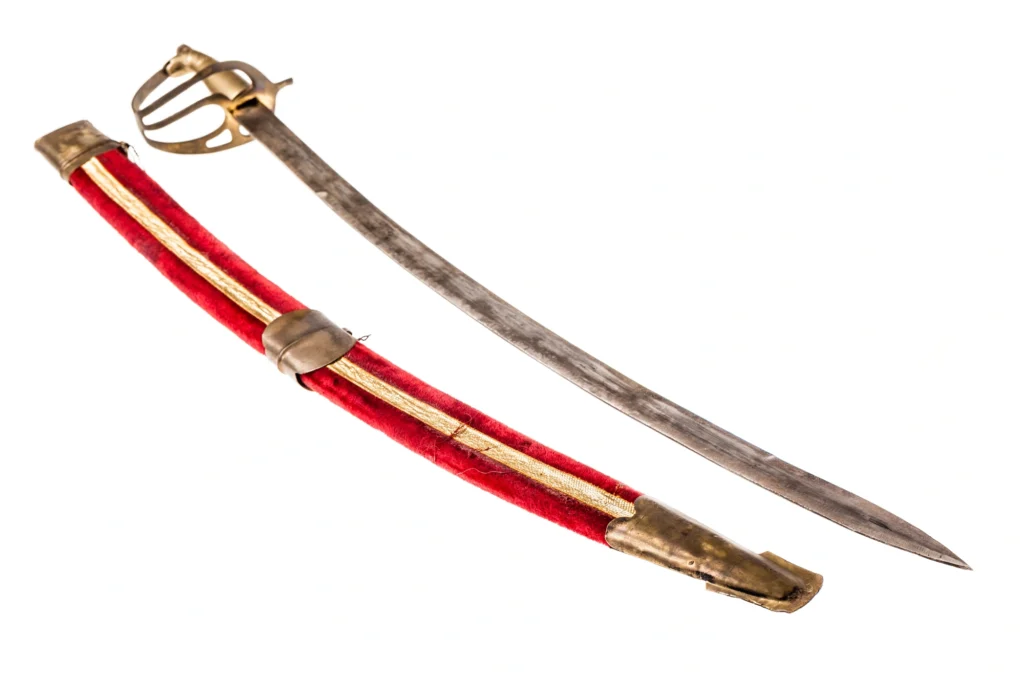 Detailed view of a sabre sword in a vibrant red scabbard, isolated on a white background, showcasing the contrast and design details.