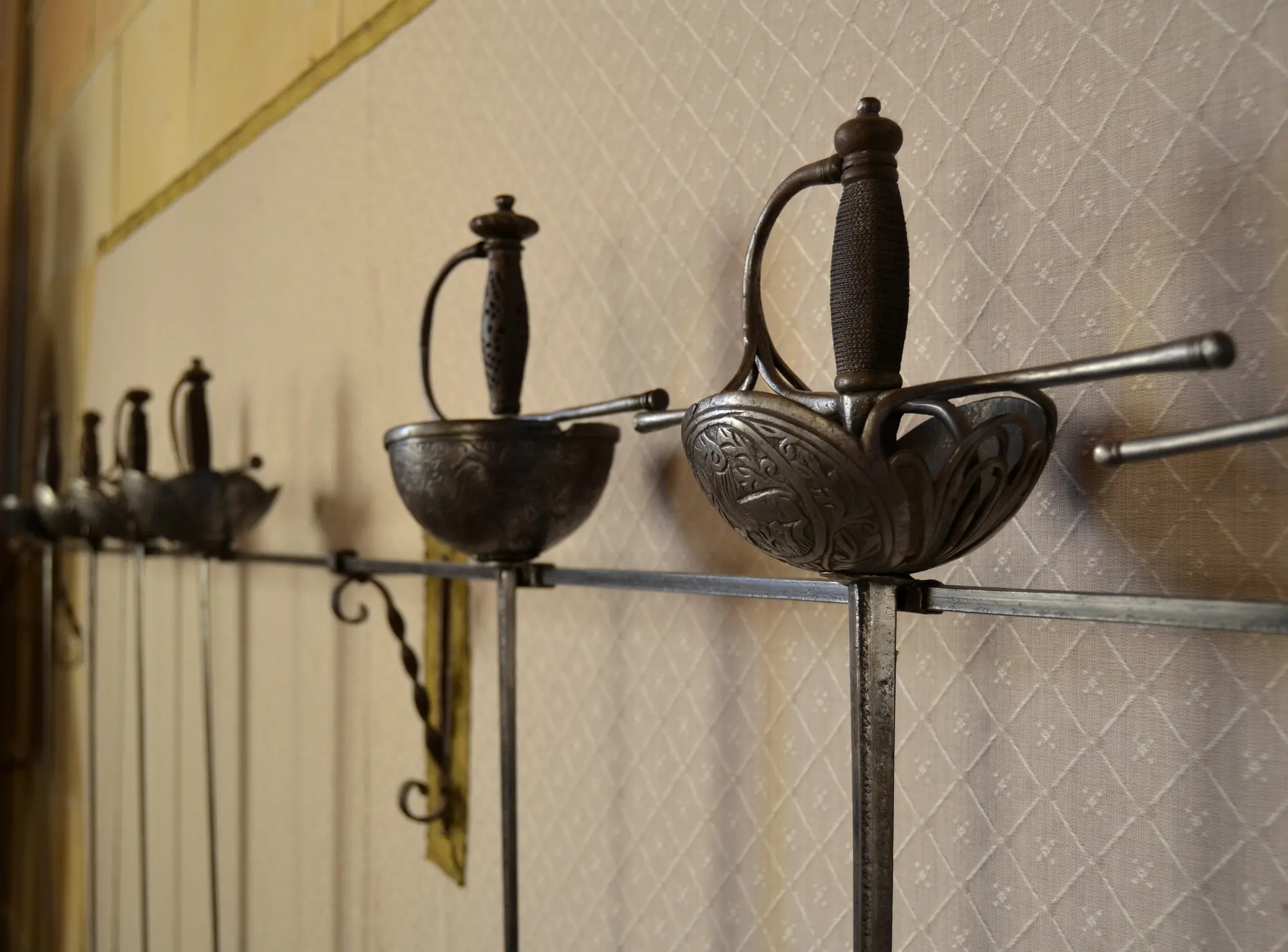 Cup-hilted Rapiers displayed in a wall.