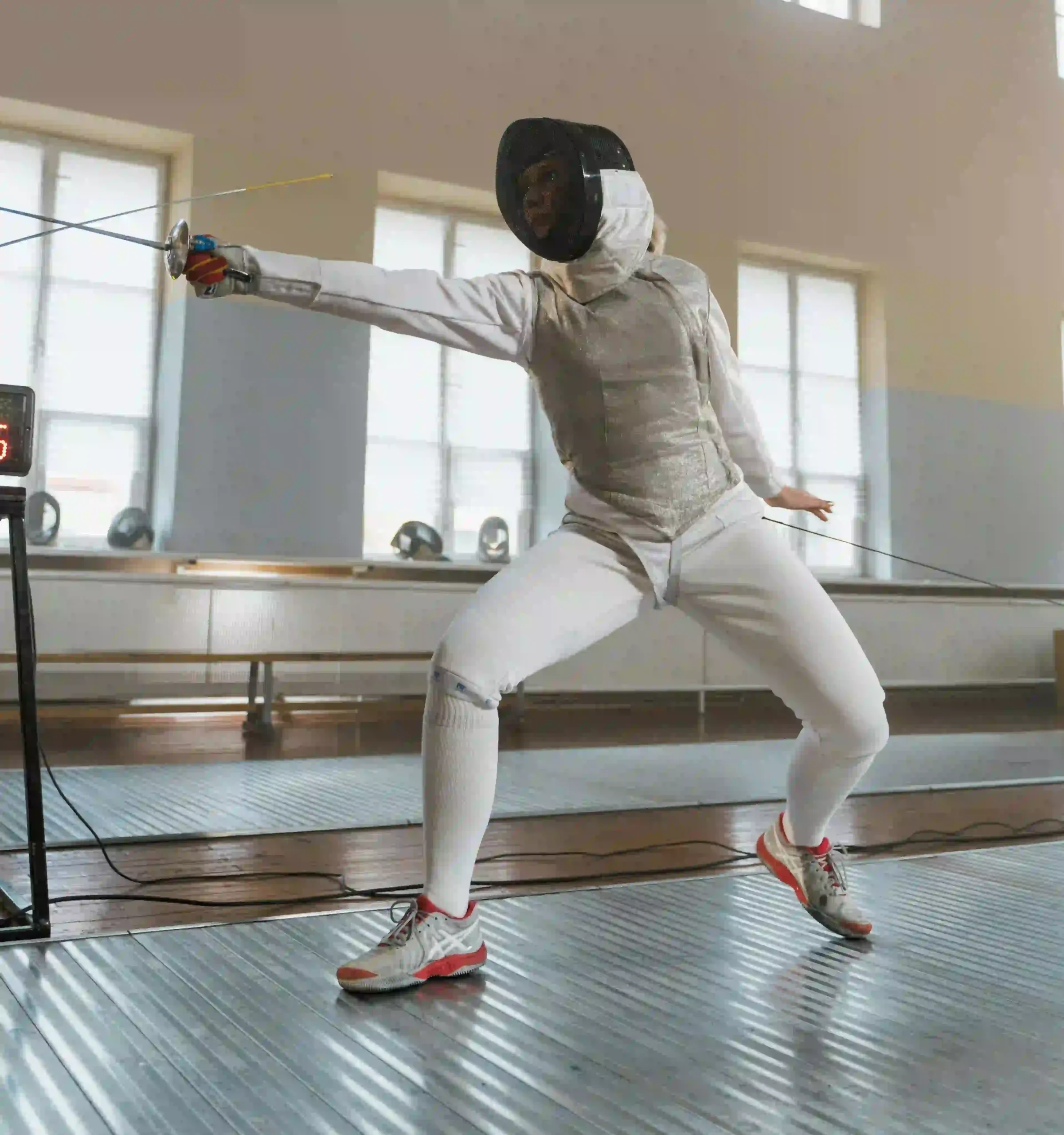 A girl during a lunge in fencing match