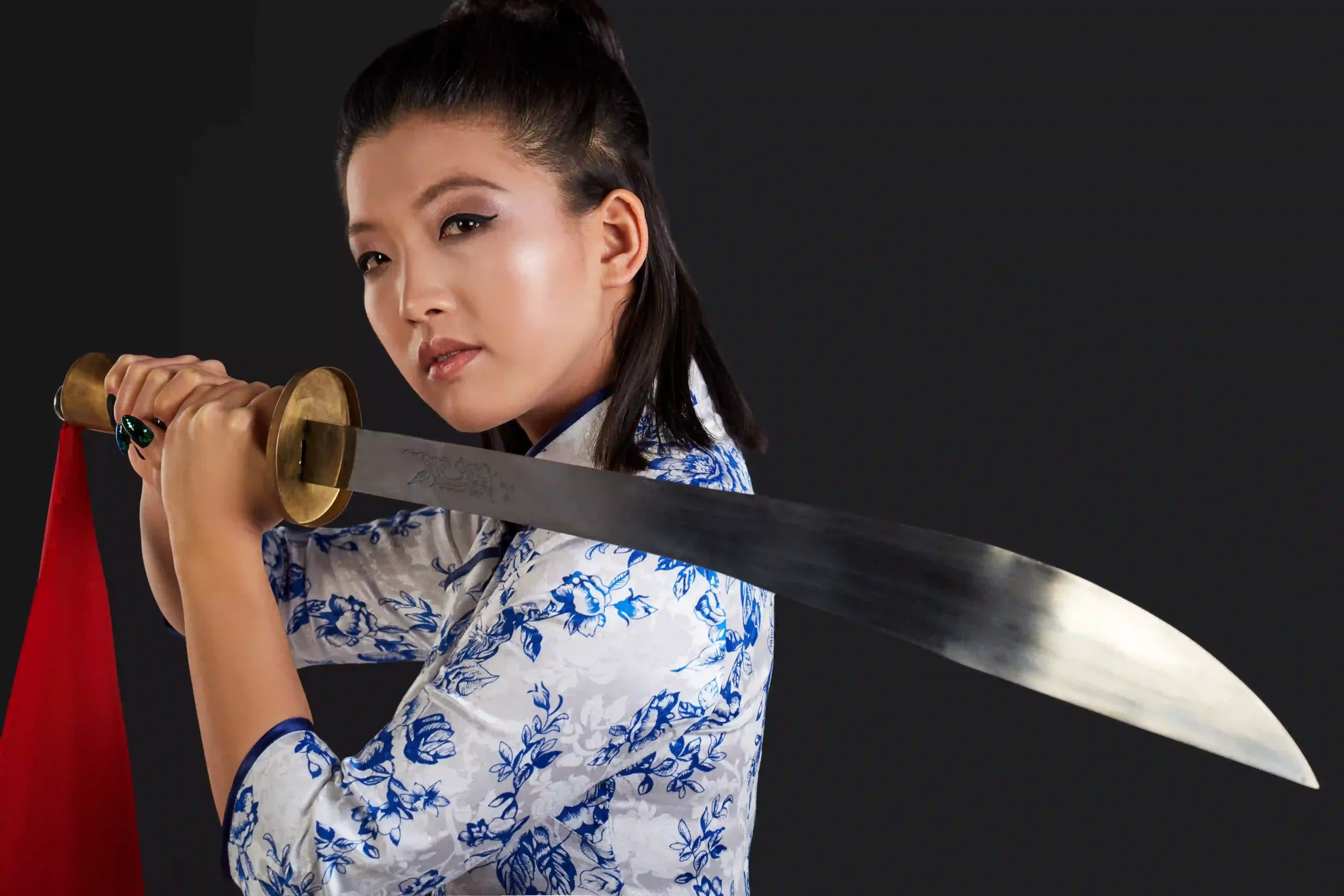 Woman holding a Chinese broadsword in a defensive stance.