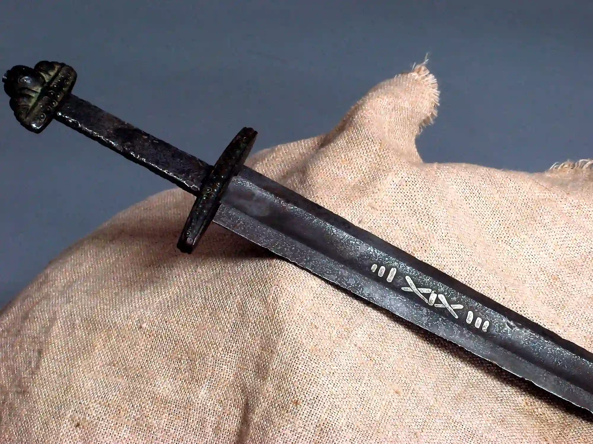 Close-up of an antique Viking sword with rune engravings.